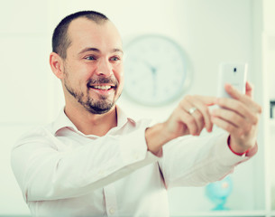 Positive young man with smartphone