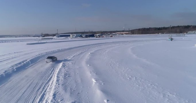 Blue and black subaru wrx racing on the ice ring, aerial view