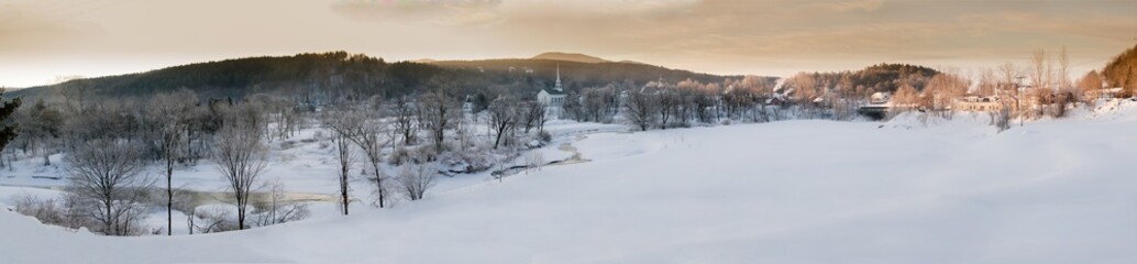 Obraz na płótnie Canvas Panaromic sunrise over Stowe Community Church on a cold winter morning, Stowe, Vermont, USA