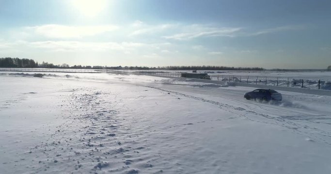 Blue and black subaru wrx racing on the ice ring, aerial view