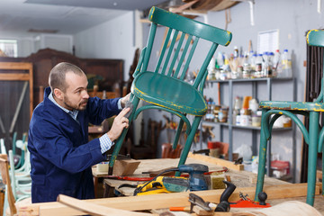 Restorer in process of renovation vintage armchair