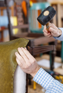 Craftsman Reupholstering Chair In Workshop