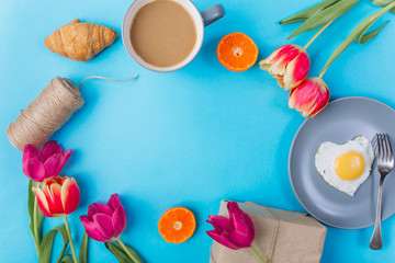 Mother's day composition.Breakfast with tulips on blue background .
