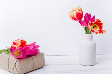 Mother's day composition.Vase with tulips and gifts