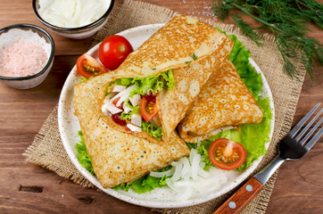 Crepes stuffed with Caesar salad, chicken, tomatoes, cheese and lettuce.