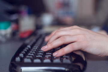 Woman's hands typing on computer keyboard, close up shot