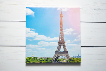Canvas print. Photo with gallery wrap method of canvas stretching on stretcher bar. Photography with image of  The Eiffel Tower (Paris, France) hanging on a white wooden wall