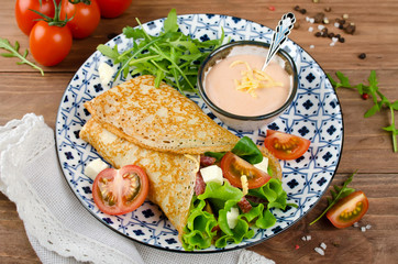 Crepes stuffed with salami, tomatoes, lettuce, mozzarella and cheese sauce.
