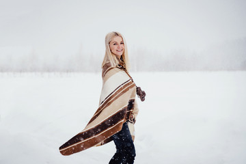 Fototapeta na wymiar Beautiful blonde girl with a vintage camera smiling against the backdrop of a winter landscape