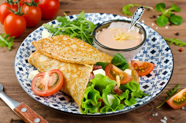 Crepes stuffed with salami, tomatoes, lettuce, mozzarella and cheese sauce.