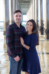 Portrait of a Happy Millennial Couple Standing at the Beach Under the Pier