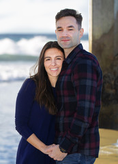 Smiling Beautiful Young Couple Standing Under the Pier Holding Hands