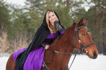 Beautiful girl in historical clothes riding a horse