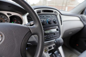 Fototapeta na wymiar Automobile interior with steering wheel, gear shift and controls