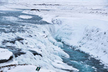 Icelandic Iceland waterfall frozen and covered in snow during winter