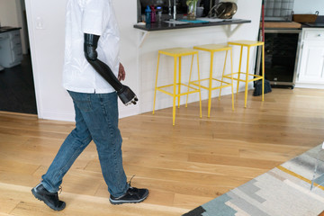 Man with robotic arm walks across room