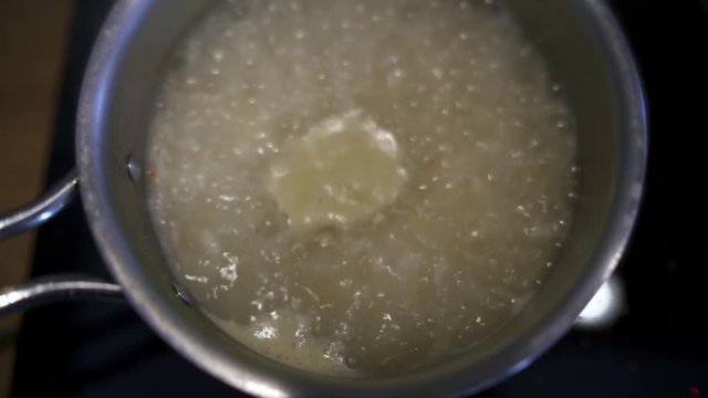 Closeup of pan with rice in boiling water (slow motion)
