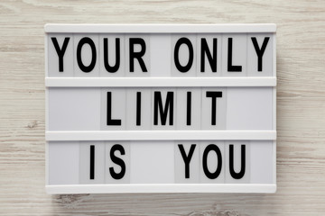 'Your only limit is you' word on modern board on a white wooden background, top view. From above, flat lay, overhead.