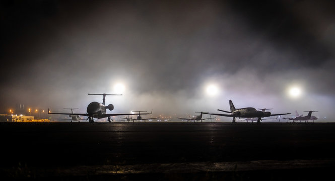 small aviation,the dark view of silhoete private jet on airport. Lights in the background