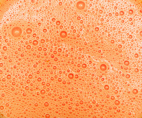 Orange carrot milkshake with bubbles texture