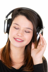 Young teenage beauty woman listening to music with earphones indoors