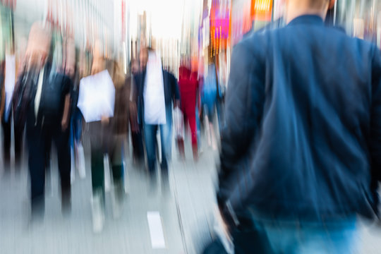 picture of people walking on a shopping street in the city, with camera made motion blur effect