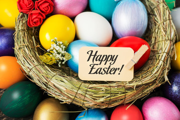 bright Easter colored eggs in Birds Nest.   Top view with copy space 