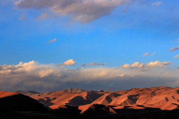 Abstract Landscape. Blue Sky, White Clouds, High Altitude Brown Mountains and Hills in the distance. Minimal Background, Open Space, Negative Space. Sichuan Province China. Tibetan Plateau Landscape