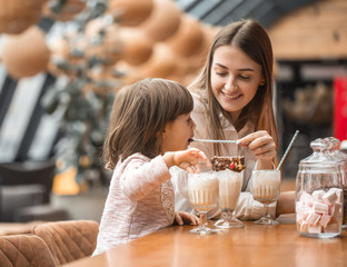 Happy young women mother with children drinking a milkshake