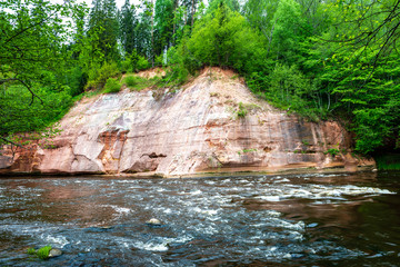 sandstone cliffs on the shore of forest river