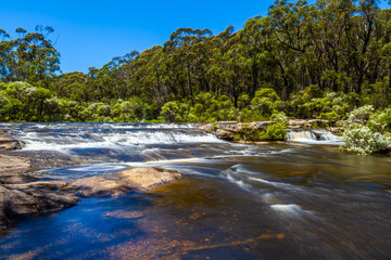 Naklejka na ściany i meble Water flowing in Kangaroo river towards Carrington Falls. New South Wales, Australia