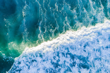 Looking down at powerful blue wave in the sea - aerial view