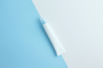 Cosmetics tube on light blue and white background. Copy space. Flat lay.