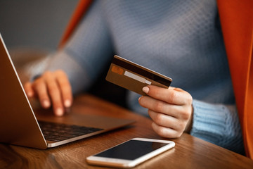 Unrecognizable woman using credit card and shopping online.