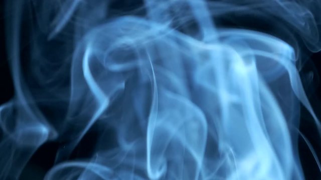 Smoke rising graceful twists on black background blowing from bottom to top. Closeup, ProRes, 50 fps