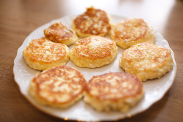 Obraz na płótnie Canvas Close up cheese pancakes, cheese cakes, cottage cheese pancakes on a white plate background.