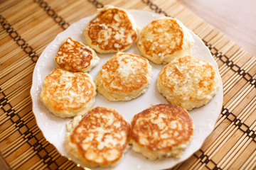 Close up cheese pancakes, cheese cakes, cottage cheese pancakes on a white plate background.