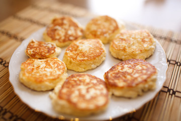 Close up cheese pancakes, cheese cakes, cottage cheese pancakes on a white plate background.