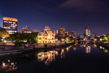 Hiroshima Skyline by night on the side of Motoyasu river in Japan with the Atomic Bomb Dome, the historic remains of the atomic blast.