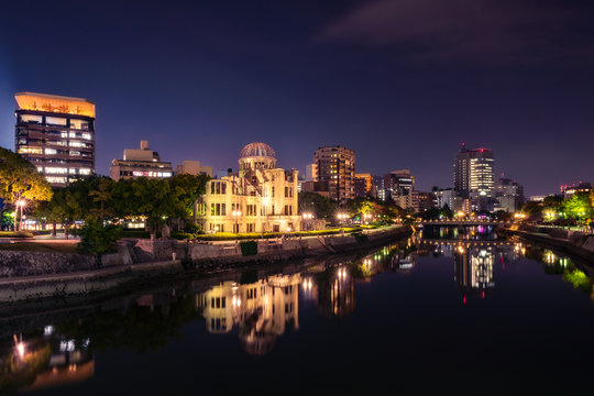 Hiroshima Skyline by night on the side of Motoyasu river in Japan with the Atomic Bomb Dome, the historic remains of the atomic blast.