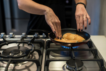 Young woman making french bread in frying pan