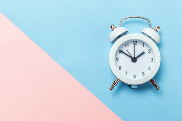 Ringing twin bell vintage classic alarm clock Isolated on blue pink pastel colorful trendy background. Rest hours time of life good morning night wake up awake concept. Flat lay top view copy space