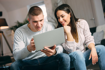 beautiful woman and handsome man using a laptop