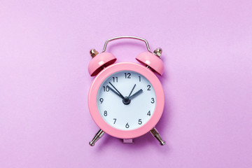 Ringing twin bell vintage classic alarm clock Isolated on purple violet pastel colourful...
