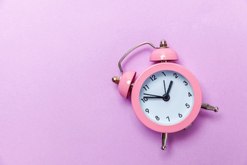 Ringing twin bell vintage classic alarm clock Isolated on purple violet pastel colourful...