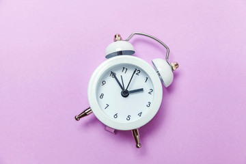 Ringing twin bell vintage classic alarm clock Isolated on purple violet pastel colourful...