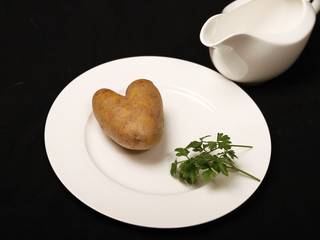 Kartoffel in Herzform auf weißem Teller