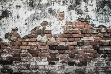 Grungy historical broken brick wall background in sunny summer day. Abstract red brick old wall texture background. Ruins uneven crumbling red brick wall background texture.