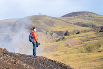 Reykjadalur, Iceland Hveragerdi Hot Springs road footpath with steam during autumn landscape morning in golden circle with woman and camera on hiking trail