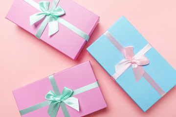 Christmas New Year birthday valentine celebration present romantic concept. Three gift boxes wrapped pink blue paper isolated on pink pastel colorful trendy background. Flat lay top view copy space